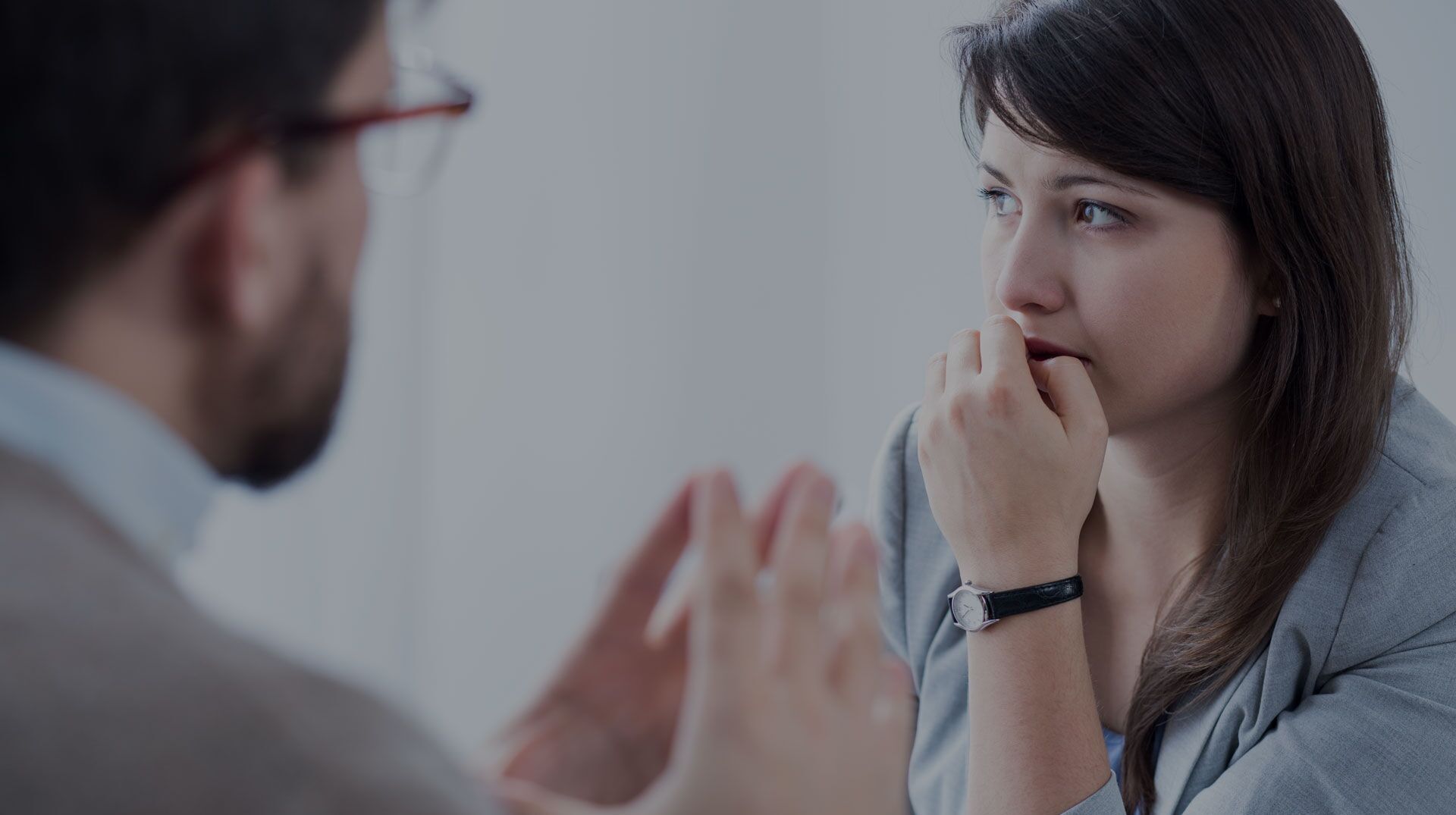 Concerned woman in a counseling session, potentially engaging in an anxiety management discussion. A woman in discussion with a male mental health professional during a mental health treatment session, focusing intently