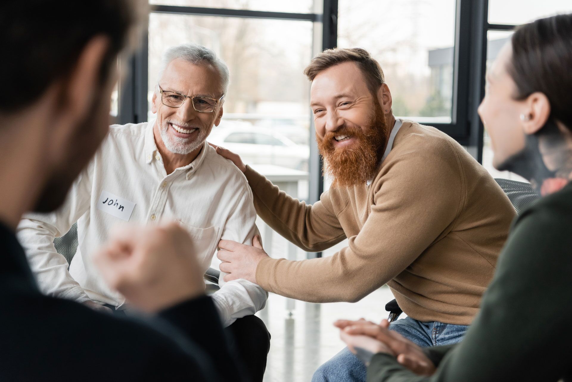 Individuals laughing together in an Adult Outpatient Programs therapy session
